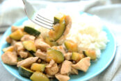 Teriyaki Garlic Chicken Stir Fry on a blue plate with rice and a fork is taking a bite