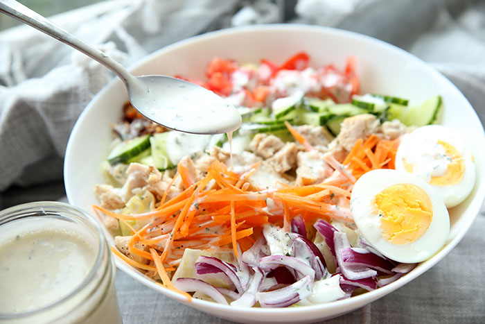 a colorful salad with egg, carrots, and onions