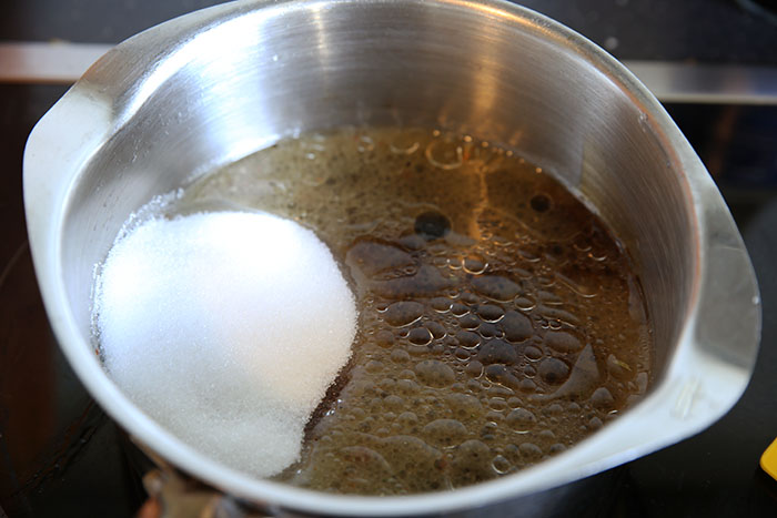 soy sauce, italian salad dressing and sugar poured into a small silver sauce pan sitting on a stove top