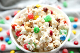 white bowl of popcorn mix with colored M&Ms