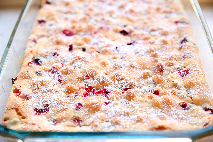 Partial picture of the whole Cranberry Christmas cake in a 9x13 pan dusted with powdered sugar.