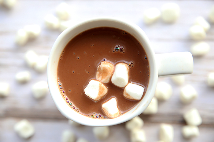 a white mug of hot chocolate with five white marshmallows
