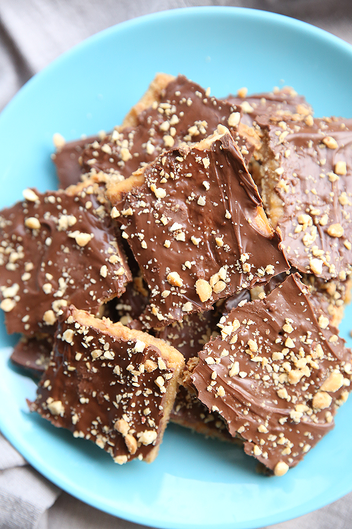 a blue plate with about ten pieces of soda cracker toffee candy on it