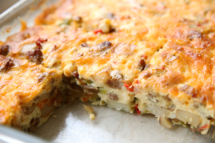 A glass casserole dish holding easy cheesy breakfast casserole with a few slices missing