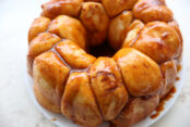 A picture showing 3/4 of butterscotch monkey bread sitting on a white plate.