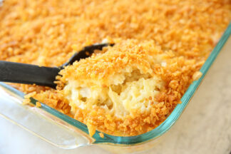 a 9x13 glass baking dish full of cheesy hashbrown casserole that is topped with buttery cornflakes