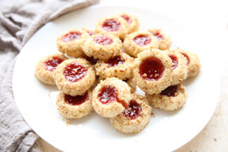 Thumbprint Cookies on a white plate. A grey kitchen towel is wrapped around the left side of the plate.