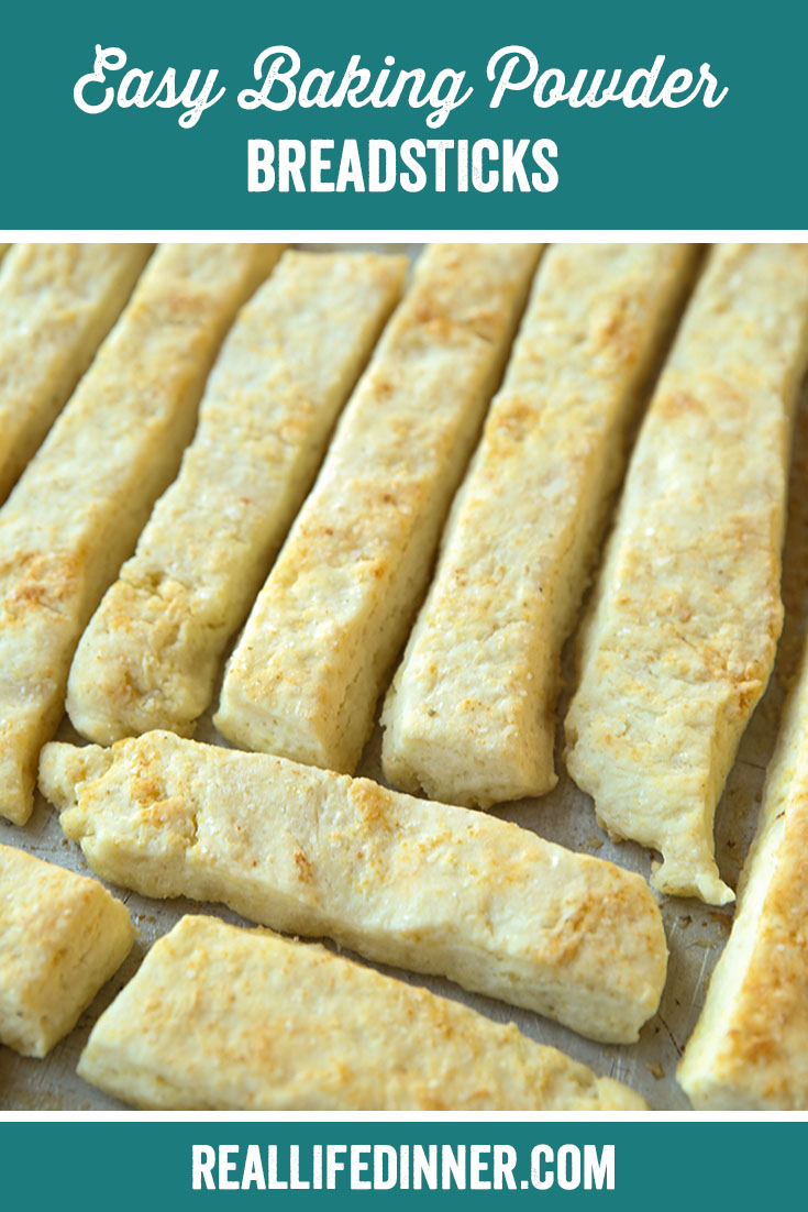 pinterest image of easy baking powder breadsticks on a hot cookie sheet just out of the oven.