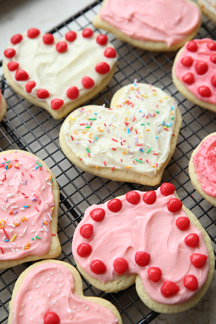 Decorated heart-shaped sugar cookies on a wire cooling rack.