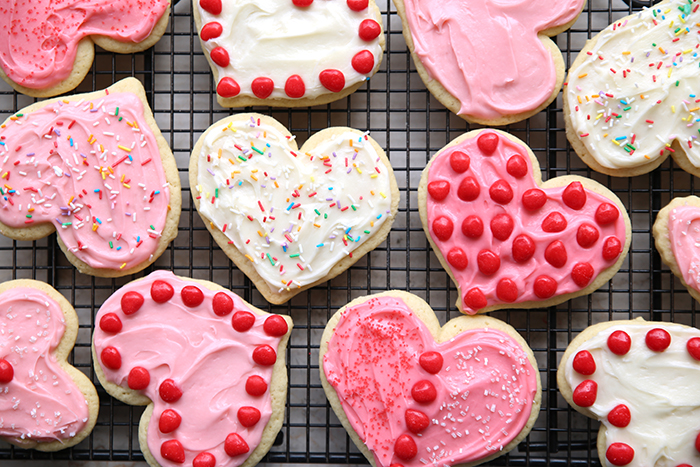 Twelve heart-shaped sugar cookies and decorated with sprinkles and Red Hot candies.