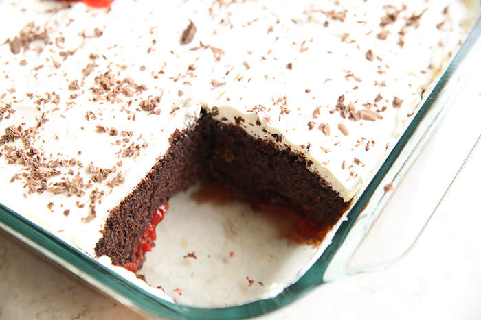 Easy Black Forest Cake in a glass 9x13 baking dish with a piece cut out of the corner.