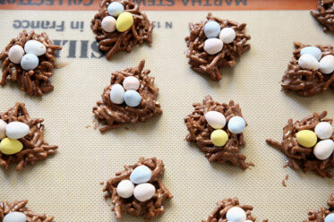 No-bake Birds Nest Cookies sitting on a Silpat mat on top of a cookie sheet.