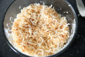 Toasted sweetened shredded coconut in a microwave-safe bowl.