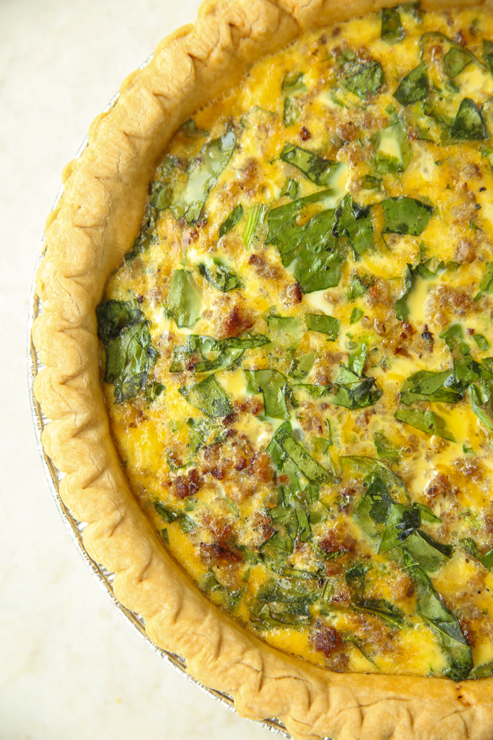 A partial picture of spinach and sausage quiche.