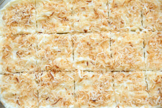 Toasted Coconut Swig Sugar Cookie Bars in a glass 9x13 dish cut into 15 squares.