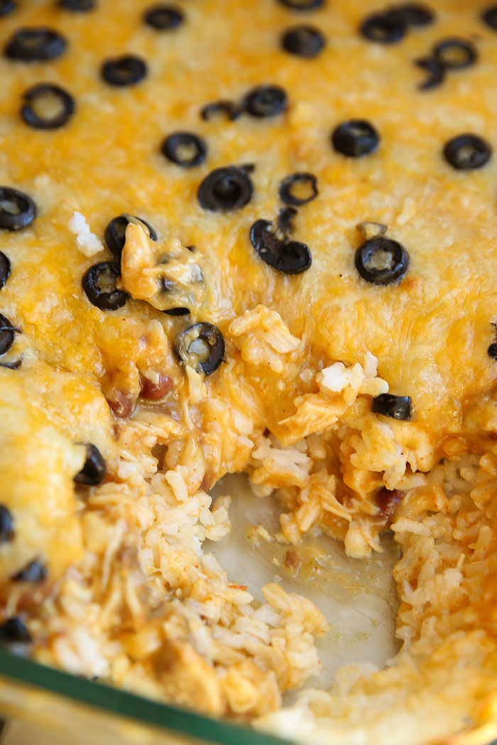 A glass 9x13 baking dish of Mexican Chicken Casserole topped with sliced black olives.
