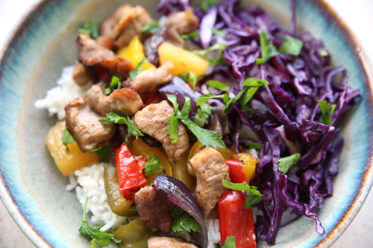Sheet pan Hawaiian pork bowl with chopped red cabbage served over coconut rice.
