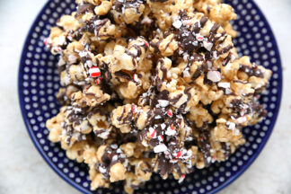 A dark blue white polka dotted Polish pottery plate of peppermint bark crunch popcorn.