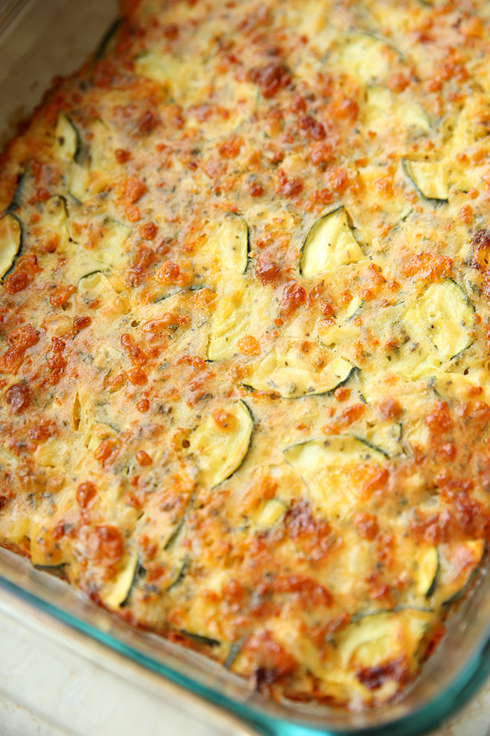 A glass 9x13 glass baking dish placed diagonally filled with zucchini pizza.