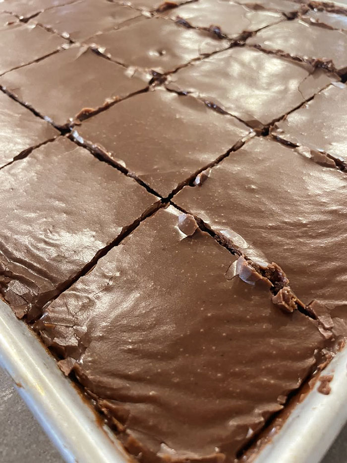 A large baking sheet of Texas sheet cake cut into squares.