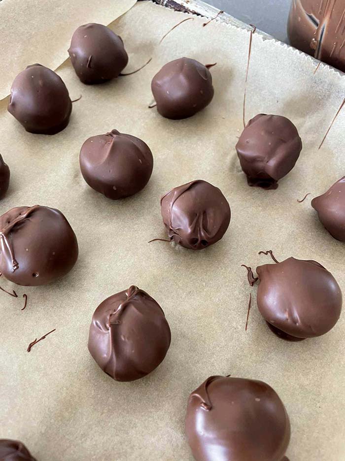 A lined baking sheet of healthy peanut butter balls.