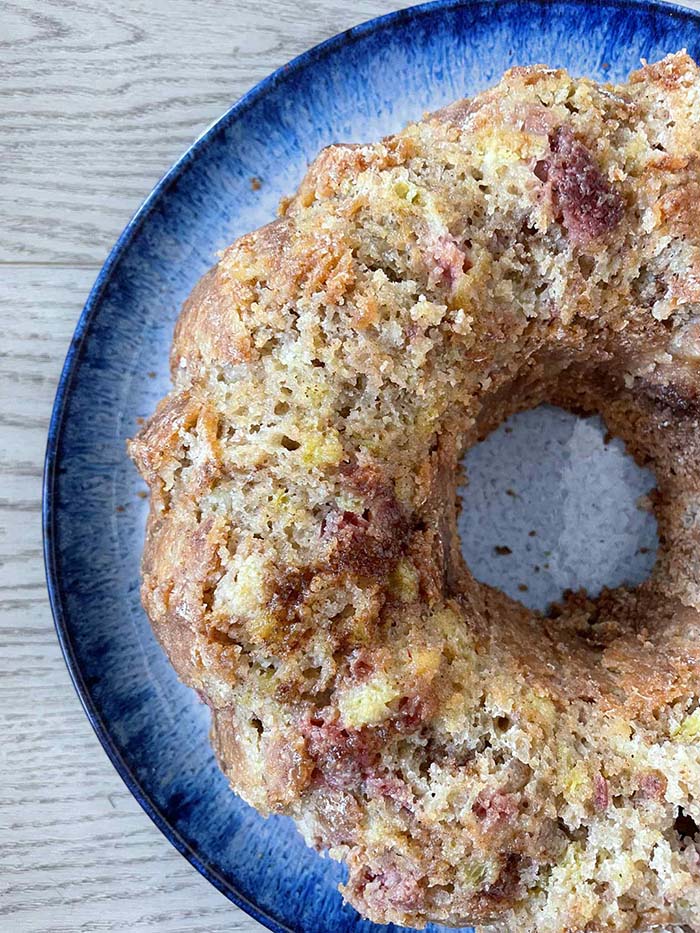 A strawberry rhubarb bundt cake on a large round plate.