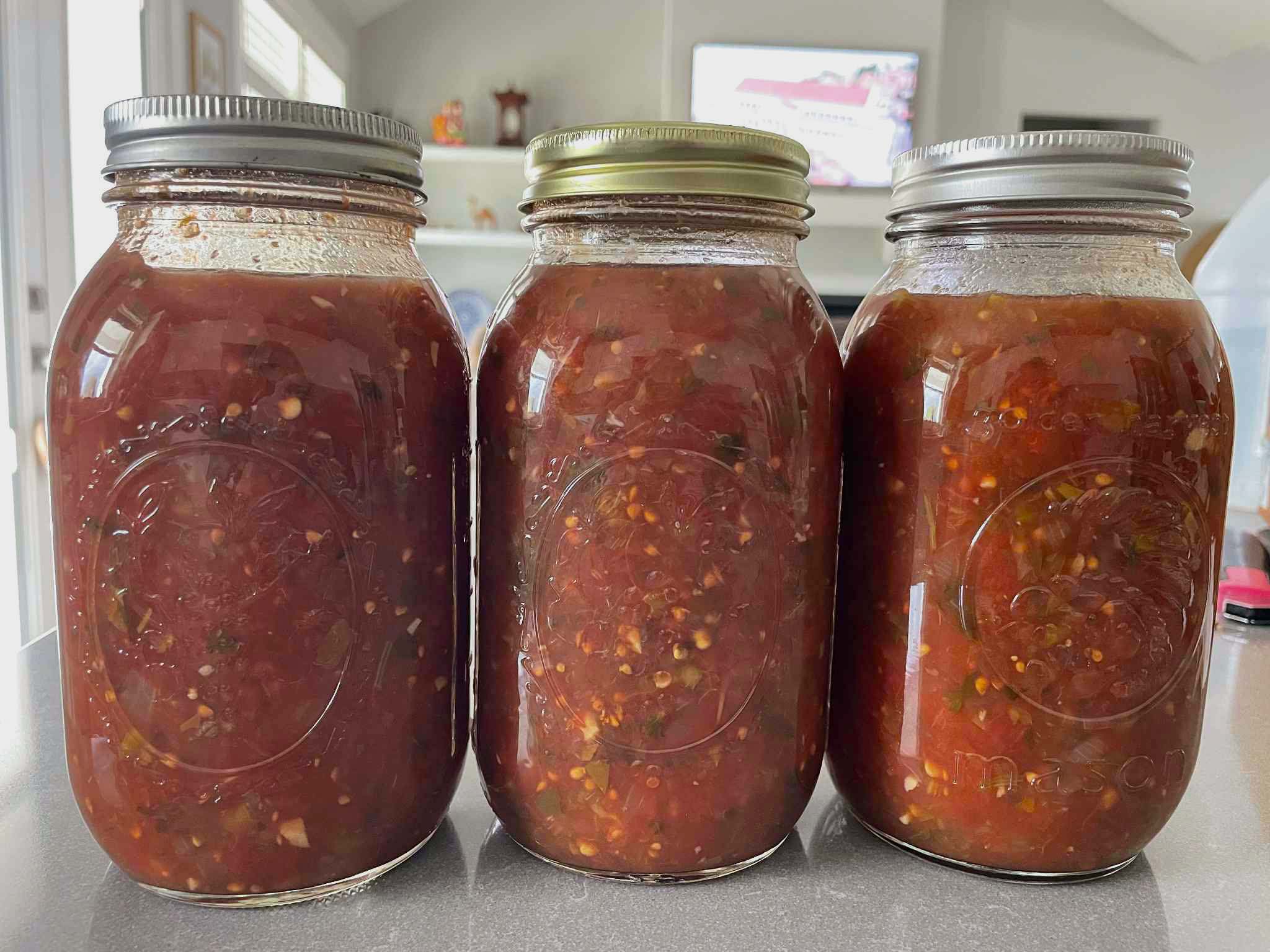 Three quart-size jars of homemade salsa.