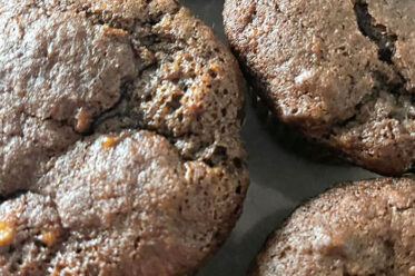 A close-up of a few chocolate banana chocolate chip muffins.