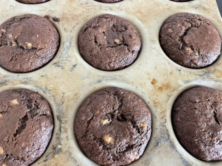 Double chocolate banana muffins in a stoneware muffin pan.
