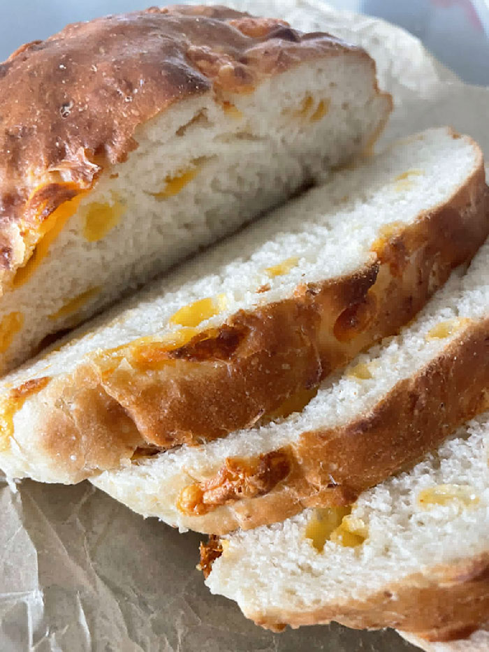 A loaf of Easy Cheesy Bread with a few cut slices.