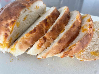A loaf of Easy Cheesy Bread with five slices stacked diagonally on each other.