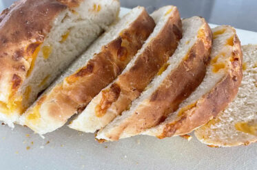 A loaf of Easy Cheesy Bread with five slices stacked diagonally on each other.