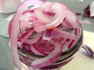 A small jar of overflowing pickled red onions.